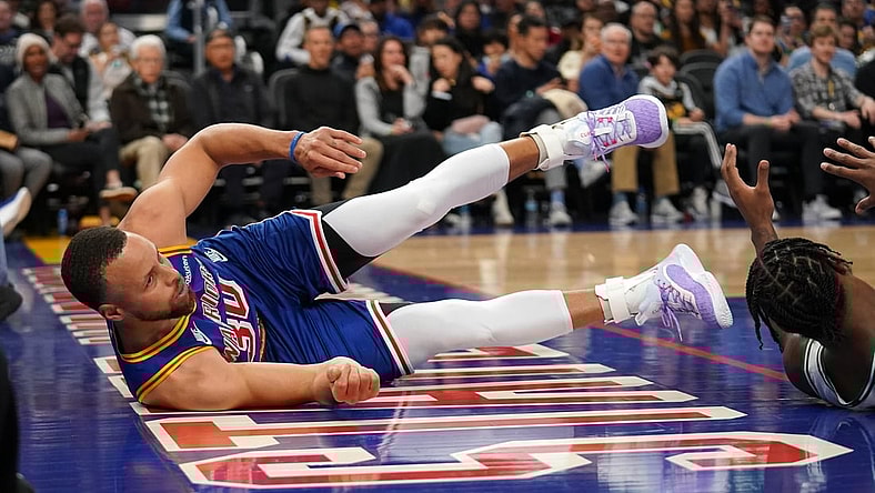 Mar 16, 2022; San Francisco, California, USA; Golden State Warriors guard Stephen Curry (30) falls on the ground after being called for an offensive foul against the Boston Celtics in the second quarter at the Chase Center. Mandatory Credit: Cary Edmondson-USA TODAY Sports