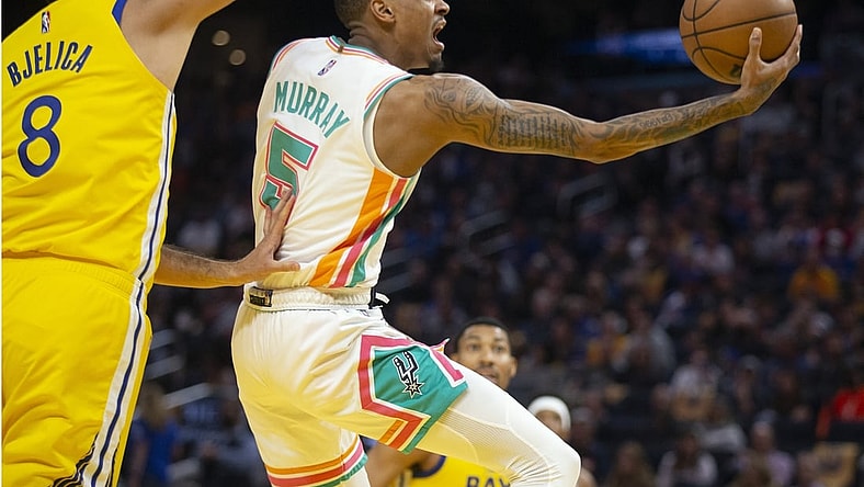 Mar 20, 2022; San Francisco, California, USA; San Antonio Spurs guard Dejounte Murray (5) drives to the basket past Golden State Warriors forward Nemanja Bjelica (8) during the first quarter at Chase Center. Mandatory Credit: D. Ross Cameron-USA TODAY Sports