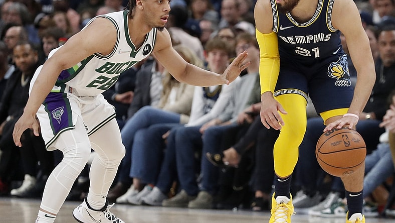 Mar 26, 2022; Memphis, Tennessee, USA;  Memphis Grizzlies guard Tyus Jones (21) controls the ball against Milwaukee Bucks guard Lindell Wigginton (28) during the second half at FedExForum. The Grizzlies won 127-102. Mandatory Credit: Christine Tannous-USA TODAY Sports