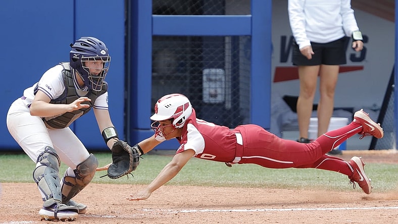 Jun 6, 2021; Oklahoma City, Oklahoma, USA;  Oklahoma's Rylie Boone (0) slides in at home past James Madison catcher Lauren Bernett (22) to score a run in the sixth inning during a Women s College World Series semi finals game at USA Softball Hall of Fame Stadium. Oklahoma won 6-3. Mandatory Credit: Alonzo Adams-USA TODAY Sports