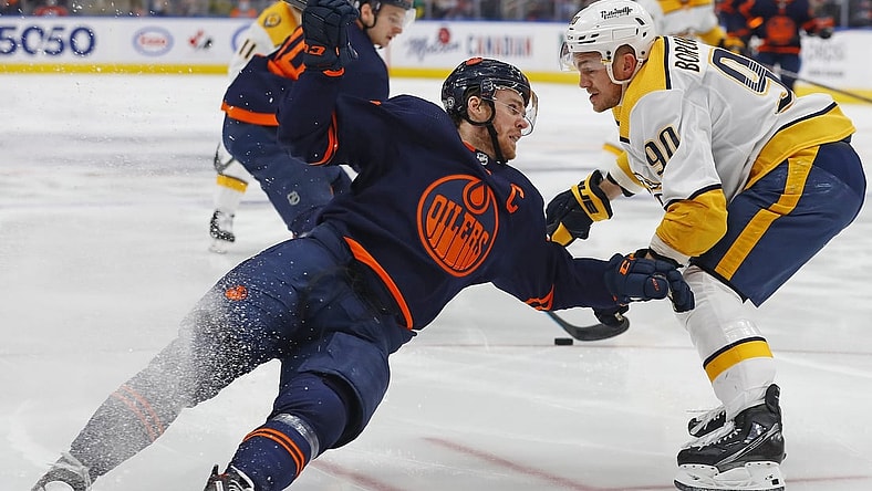 Jan 27, 2022; Edmonton, Alberta, CAN; /n90- trips up Edmonton Oilers forward Connor McDavid (97) during the third period at Rogers Place. Mandatory Credit: Perry Nelson-USA TODAY Sports