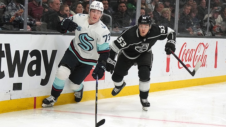 Mar 28, 2022; Los Angeles, California, USA; Seattle Kraken right wing Kole Lind (73) and LA Kings defenseman Jordan Spence (53) battle for the puck at Crypto.com Arena. Mandatory Credit: Kirby Lee-USA TODAY Sports