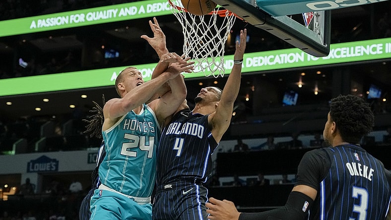 Apr 7, 2022; Charlotte, North Carolina, USA; Charlotte Hornets center Mason Plumlee (24) gets fouled on his shot attempt by Orlando Magic guard Jalen Suggs (4) during the first quarter at Spectrum Center. Mandatory Credit: Jim Dedmon-USA TODAY Sports