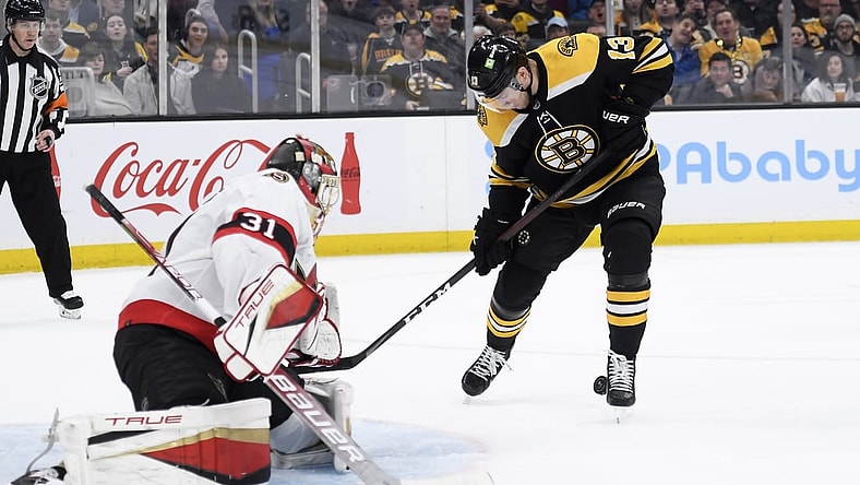 Apr 14, 2022; Boston, Massachusetts, USA;  Boston Bruins center Charlie Coyle (13) tries to control a rebound in front of Ottawa Senators goaltender Anton Forsberg (31) during the first period at TD Garden. Mandatory Credit: Bob DeChiara-USA TODAY Sports