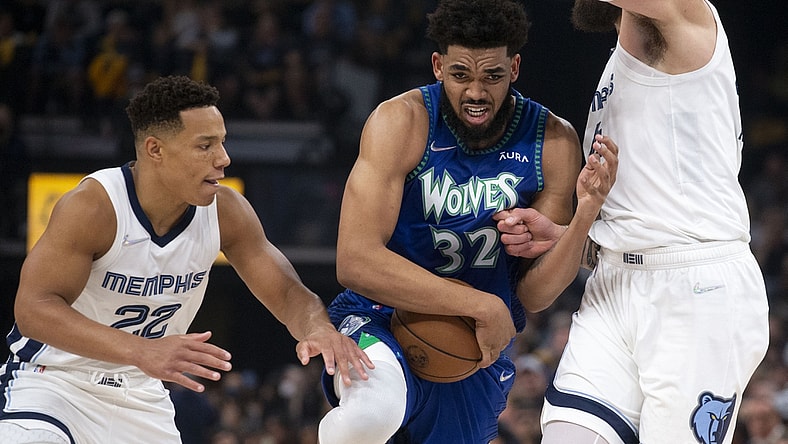 Apr 16, 2022; Memphis, Tennessee, USA; Minnesota Timberwolves center Karl-Anthony Towns (32) keeps control of the ball as he   s guarded by Memphis Grizzlies guard Desmond Bane (22) and Memphis Grizzlies center Steven Adams (4) during the first half of game one of the first round for the 2022 NBA playoffs at FedExForum. Mandatory Credit: Christine Tannous-USA TODAY Sports
