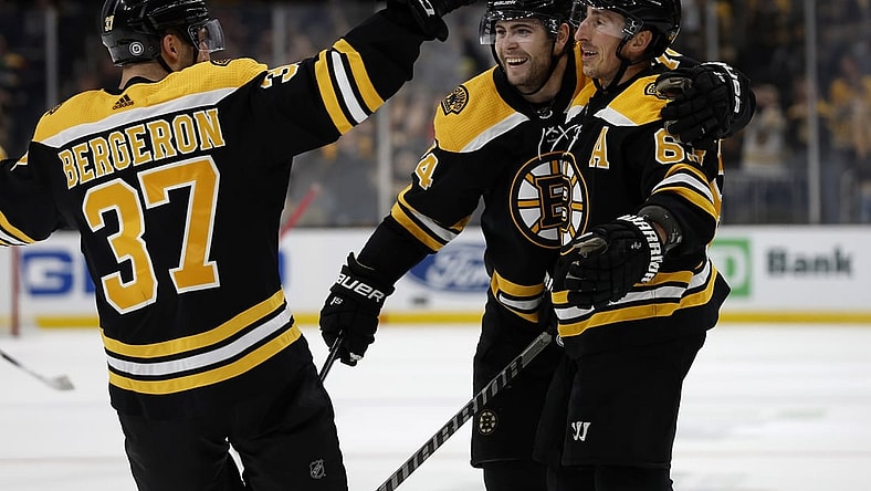 Apr 26, 2022; Boston, Massachusetts, USA; Boston Bruins left wing Brad Marchand (63) is congratulated by left wing Jake DeBrusk (74) and center Patrice Bergeron (37) after scoring against the Florida Panthers during the third period at TD Garden. Mandatory Credit: Winslow Townson-USA TODAY Sports