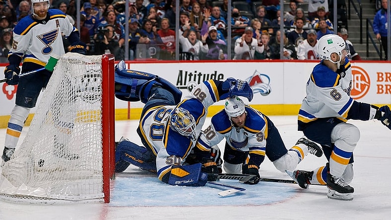 Apr 26, 2022; Denver, Colorado, USA; St. Louis Blues goaltender Jordan Binnington (50) dives for the puck as it hits the back of the net as center Ryan O'Reilly (90) and defenseman Marco Scandella (6) defend as Colorado Avalanche center Alex Newhook (18) lies on the ice in the second period at Ball Arena. Mandatory Credit: Isaiah J. Downing-USA TODAY Sports