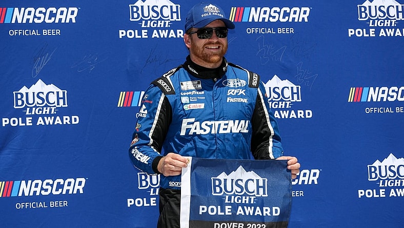 Apr 30, 2022; Dover, Delaware, USA; NASCAR Cup Series driver Chris Buescher stands with the Busch Light Pole Award after winning the pole during qualifying for the DuraMAX Drydene 400 at Dover Motor Speedway. Mandatory Credit: Matthew OHaren-USA TODAY Sports