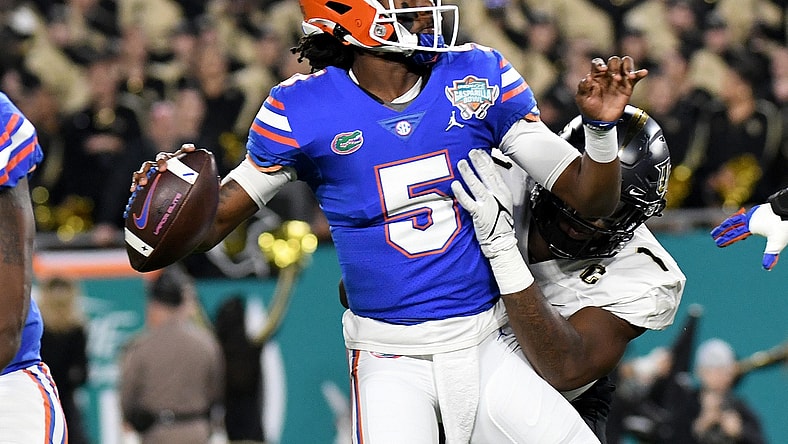 Dec 23, 2021; Tampa, FL, USA;  Florida Gators quarterback Emory Jones (5) is hit by UCF Knights defensive lineman Big Kat Bryant (1) on a pass attempt in the first half of the Gasparilla Bowl at Raymond James Stadium. Mandatory Credit: Jonathan Dyer-USA TODAY Sports