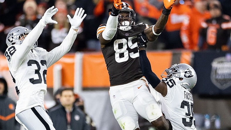 Dec 20, 2021; Cleveland, Ohio, USA; Cleveland Browns tight end David Njoku (85) leaps for the ball along with Las Vegas Raiders defensive back Dallin Leavitt (32) and cornerback Brandon Facyson (35) during the fourth quarter at FirstEnergy Stadium. Mandatory Credit: Scott Galvin-USA TODAY Sports