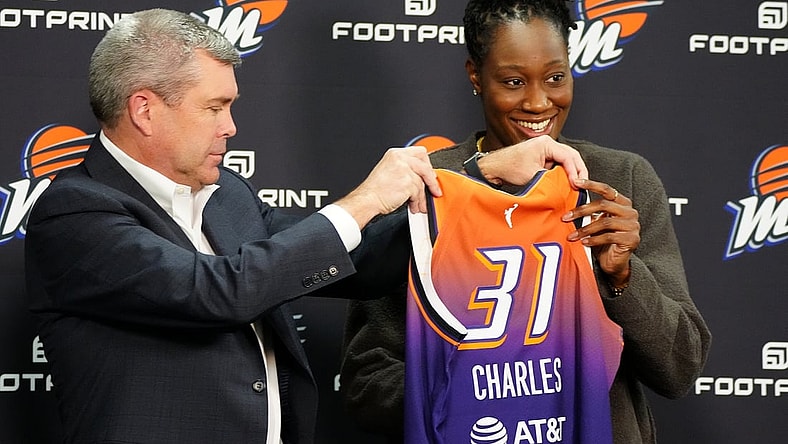 Feb 10, 2022; Phoenix, Arizona, USA; Phoenix Mercury general manager Jim Pitman (left) and Tina Charles hold up her jersey during Charles    introductory press conference at Footprint Center. Mandatory Credit: Patrick Breen-The Republic