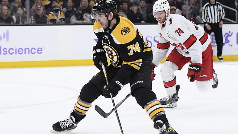 Feb 10, 2022; Boston, Massachusetts, USA; Boston Bruins left wing Jake DeBrusk (74) skates in on goal while Carolina Hurricanes defenseman Jaccob Slavin (74) pursues during the third period at TD Garden. Mandatory Credit: Bob DeChiara-USA TODAY Sports
