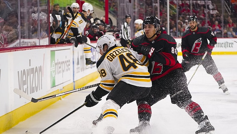 May 2, 2022; Raleigh, North Carolina, USA; Carolina Hurricanes left wing Teuvo Teravainen (86) hits Boston Bruins defenseman Matt Grzelcyk (48) during the first period in game one of the first round of the 2022 Stanley Cup Playoffs at PNC Arena. Mandatory Credit: James Guillory-USA TODAY Sports