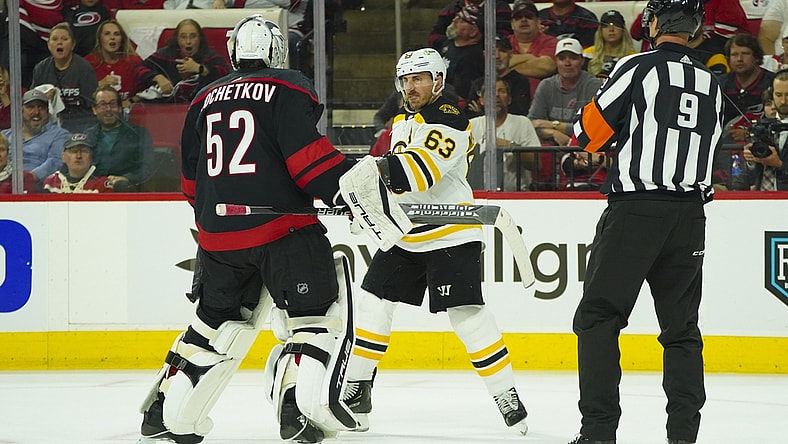 May 4, 2022; Raleigh, North Carolina, USA; Boston Bruins left wing Brad Marchand (63) swings his stick at Carolina Hurricanes goaltender Pyotr Kochetkov (52) during the second period in game two of the first round of the 2022 Stanley Cup Playoffs at PNC Arena. Mandatory Credit: James Guillory-USA TODAY Sports