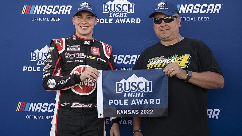 May 14, 2022; Kansas City, Kansas, USA; NASCAR Cup Series driver Christopher Bell (left) reacts after securing the pole position during AdventHealth 400 qualifying at Kansas Speedway. Mandatory Credit: Amy Kontras-USA TODAY Sports