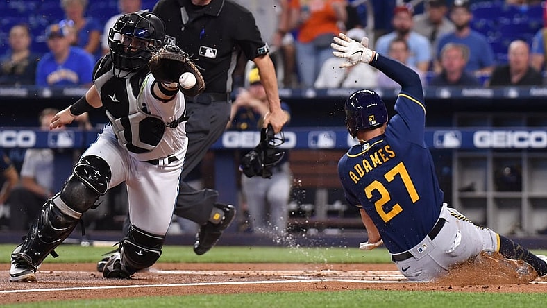 May 15, 2022; Miami, Florida, USA; Milwaukee Brewers Willy Adames (27) slides ahead of the throw received by  Miami Marlins catcher Payton Henry (59) during the first inning at loanDepot Park. Mandatory Credit: Jim Rassol-USA TODAY Sports
