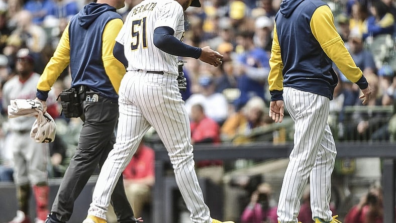 May 22, 2022; Milwaukee, Wisconsin, USA; Milwaukee Brewers pitcher Freddy Peralta (51) leaves the game with manager Craig Counsell after experiencing right shoulder tightness in the fourth inning during game against the Washington Nationals at American Family Field. Mandatory Credit: Benny Sieu-USA TODAY Sports