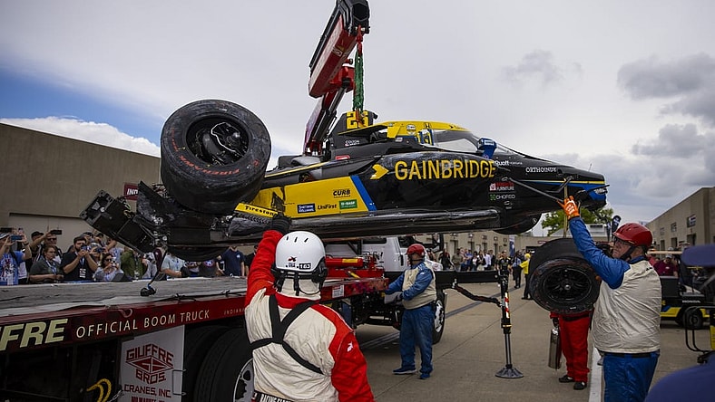 May 27, 2022; Indianapolis, Indiana, USA; The crashed car of IndyCar Series driver Colton Herta is unloaded by a tow truck in the garage area after crashing during Carb Day practice at Indianapolis Motor Speedway. Mandatory Credit: Mark J. Rebilas-USA TODAY Sports