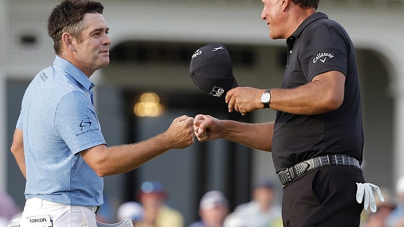 May 22, 2021; Kiawah Island, South Carolina, USA; Louis Oosthuizen (L) and Phil Mickelson (R) share a fist bump after completing their round during the third round of the PGA Championship golf tournament. Mandatory Credit: Geoff Burke-USA TODAY Sports