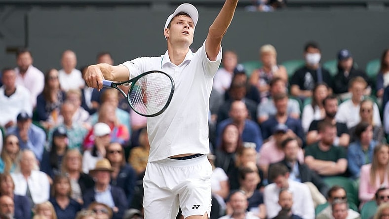 Jul 7, 2021; London, United Kingdom; Hubert Hurkacz (POL) seen in service action against Roger Federer (SUI) in the quarter finals at All England Lawn Tennis and Croquet Club. Mandatory Credit: Peter van den Berg-USA TODAY Sports