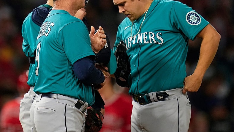 Sep 25, 2021; Anaheim, California, USA; Seattle Mariners manager Scott Servais (9) talks to relief pitcher Erik Swanson (50) during in the fifth inning against the Los Angeles Angels at Angel Stadium. Mandatory Credit: Robert Hanashiro-USA TODAY Sports