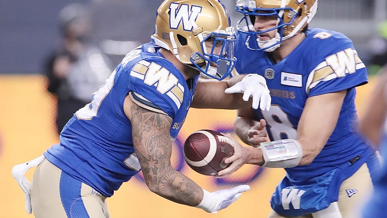 Nov 6, 2021; Winnipeg, Manitoba, CAN; Winnipeg Blue Bombers quarterback Zach Collaros (8) hands the ball off to Winnipeg Blue Bombers running back Brady Oliveira (20) against the Montreal Alouettes during the 2nd quarter during a Canadian football League game at IG Field. Mandatory Credit: Bruce Fedyck-USA TODAY Sports