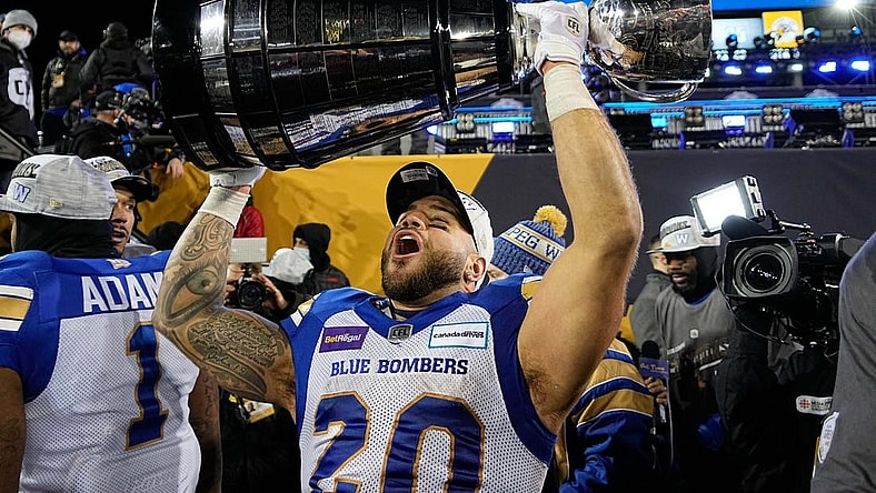 Dec 12, 2021; Hamilton, Ontario, CAN; Winnipeg Blue Bombers running back Brady Oliveira (20) celebrates with the Grey Cup after a win over the Hamilton Tiger-Cats in the 108th Grey Cup football game at Tim Hortons Field. Mandatory Credit: John E. Sokolowski-USA TODAY Sports