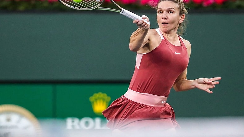 Simona Halep of Romania returns to Iga Swiatek of Poland during the WTA semifinals at the BNP Paribas Open at the Indian Wells Tennis Garden in Indian Wells, Calif., Friday, March 18, 2022.