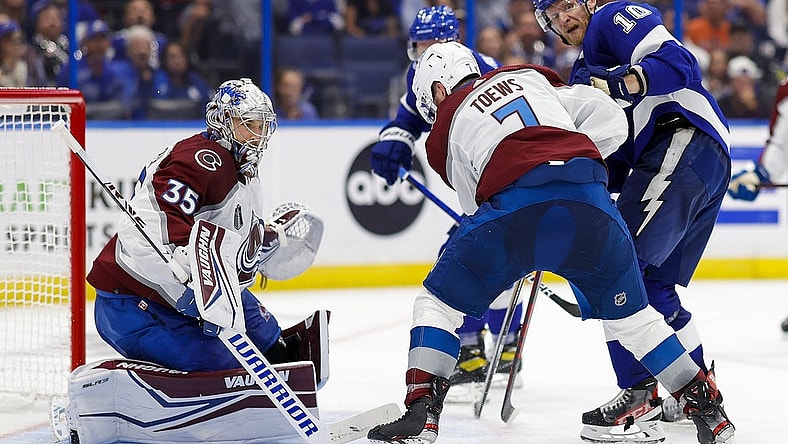 Jun 22, 2022; Tampa, Florida, USA; Tampa Bay Lightning right wing Corey Perry (10) and defenseman Devon Toews (7) battle for the puck in front of goaltender Darcy Kuemper (35) during the second period in game four of the 2022 Stanley Cup Final at Amalie Arena. Mandatory Credit: Geoff Burke-USA TODAY Sports