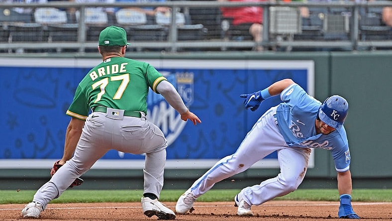 Jun 25, 2022; Kansas City, Missouri, USA;  Kansas City Royals left fielder Andrew Benintendi (16) avoids the tag from Oakland Athletics third baseman Jonah Bride (77) at third base during the first inning at Kauffman Stadium. Mandatory Credit: Peter Aiken-USA TODAY Sports