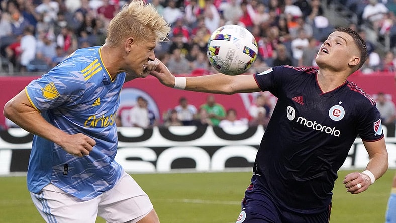 Jun 29, 2022; Chicago, Illinois, USA; Philadelphia Union defender Jakob Glesnes (5) heads the ball against Chicago Fire forward Chris Mueller (8) during the first half at Soldier Field. Mandatory Credit: Mike Dinovo-USA TODAY Sports