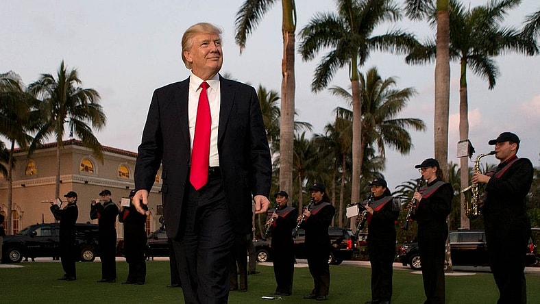 President Donald Trump listens to the Palm Beach Central band as he arrives at Trump International Golf Club to watch the Super Bowl in West Palm Beach, Florida on February 5, 2017.