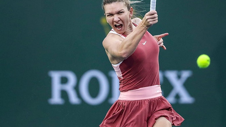 Simona Halep of Romania hits to Iga Swiatek of Poland during the WTA semifinals at the BNP Paribas Open at the Indian Wells Tennis Garden in Indian Wells, Calif., Friday, March 18, 2022.
