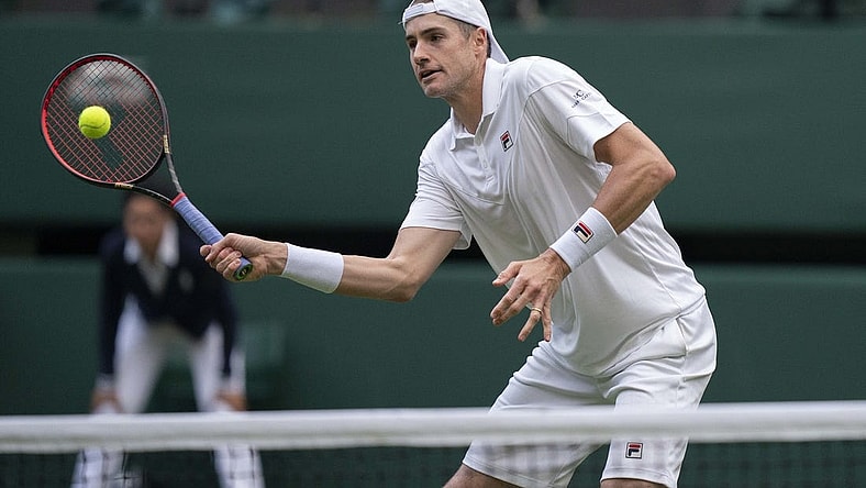 Jun 29, 2022; London, United Kingdom; John Isner (USA) returns a shot during his second round match against Andy Murray (GBR) on day three at All England Lawn Tennis and Croquet Club. Mandatory Credit: Susan Mullane-USA TODAY Sports