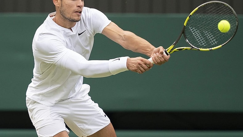 Jul 3, 2022; London, United Kingdom; Carlos Alcaraz (ESP) returns a shot during his match against Jannik Sinner (ITA) on day seven at All England Lawn Tennis and Croquet Club. Mandatory Credit: Susan Mullane-USA TODAY Sports