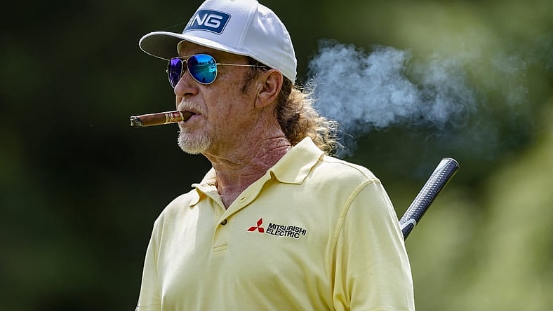 May 29, 2022; Benton Harbor, Michigan, USA; Miguel Angel Jimenez walks off the tee box while smoking a cigar on the thirteenth hole during the final round of the 2022 KitchenAid Senior PGA Championship at Harbor Shores. Mandatory Credit: Raj Mehta-USA TODAY Sports