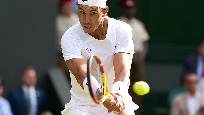 Jul 6, 2022; London, England, United Kingdom; Rafael Nadal (ESP) returns a shot during his quarter finals men   s singles match against Taylor Fritz (USA) on Centre court at All England Lawn Tennis and Croquet Club. Mandatory Credit: Peter van den Berg-USA TODAY Sports