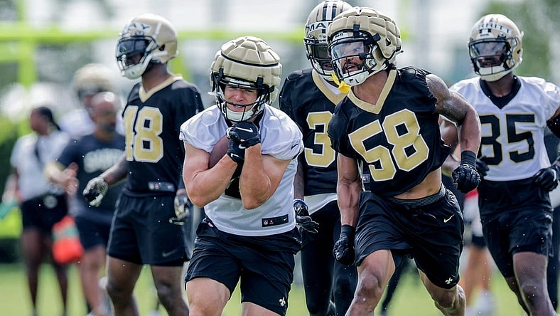 Jul 28, 2022; Metairie, LA, USA;  New Orleans Saints linebacker Eric Wilson (58) attempts to punch the ball from quarterback Taysom Hill (7) during training camp at Ochsner Sports Performance Center. Mandatory Credit: Stephen Lew-USA TODAY Sports