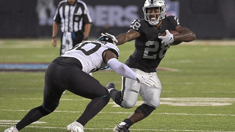 Aug 4, 2022; Canton, Ohio, USA; Las Vegas Raiders running back Josh Jacobs (28) runs against Jacksonville Jaguars linebacker Shaquille Quarterman (50) in the first quarter at Tom Benson Hall of Fame Stadium. Mandatory Credit: Ken Blaze-USA TODAY Sports