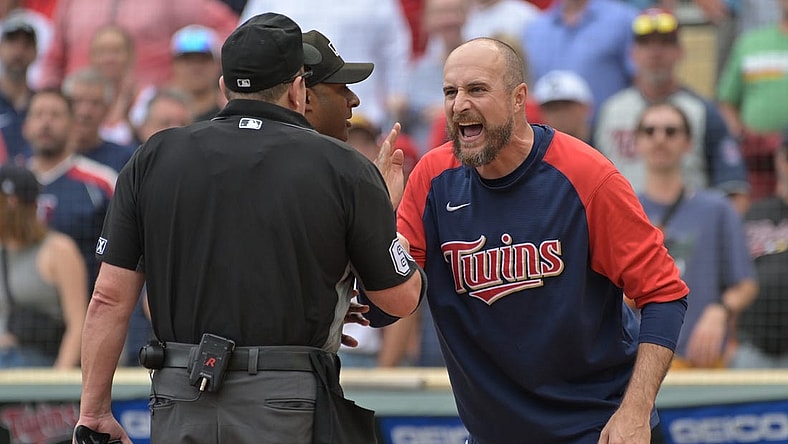 Aug 7, 2022; Minneapolis, Minnesota, USA; Minnesota Twins manager Rocco Baldelli (5) reacts with umpire Marty Foster (60) and umpire Alan Porter (64) to an overturned call during the tenth inning at Target Field. Mandatory Credit: Jeffrey Becker-USA TODAY Sports