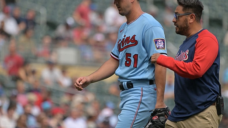 Aug 17, 2022; Minneapolis, Minnesota, USA; Minnesota Twins starting pitcher Tyler Mahle (51) comes off the field with the team trainer during the third inning against the Kansas City Royals at Target Field. Mandatory Credit: Jeffrey Becker-USA TODAY Sports