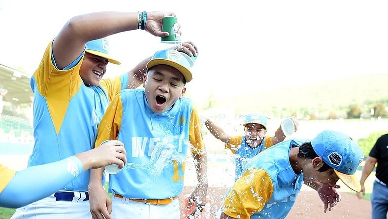 Aug 28, 2022; Williamsport, PA, USA; West Region shortstop Kekoa Payanal (15) and outfielder Kama Angell (14) get doused with gatorade by first baseman Esaiah Wong (20) and third baseman Daly Watson (12) after beating the Caribbean Region 13-3 at Lamade Stadium. Mandatory Credit: Evan Habeeb-USA TODAY Sports