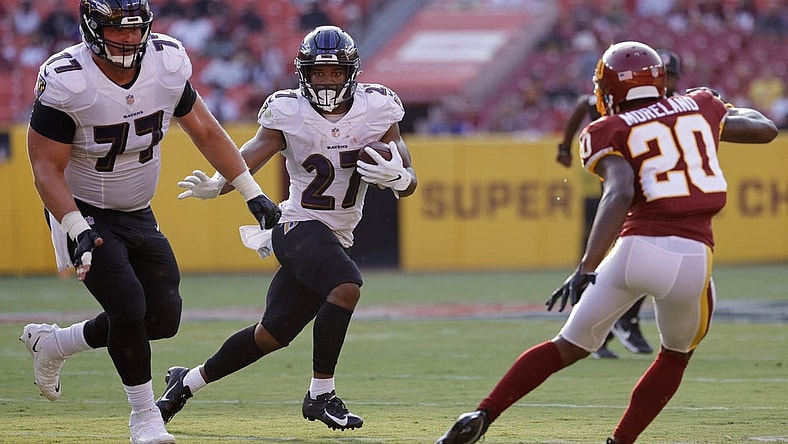 Aug 28, 2021; Landover, Maryland, USA; Baltimore Ravens running back J.K. Dobbins (27) carries the ball as Washington Football Team cornerback Kendall Fuller (29) defends in the first quarter at FedExField. Mandatory Credit: Geoff Burke-USA TODAY Sports