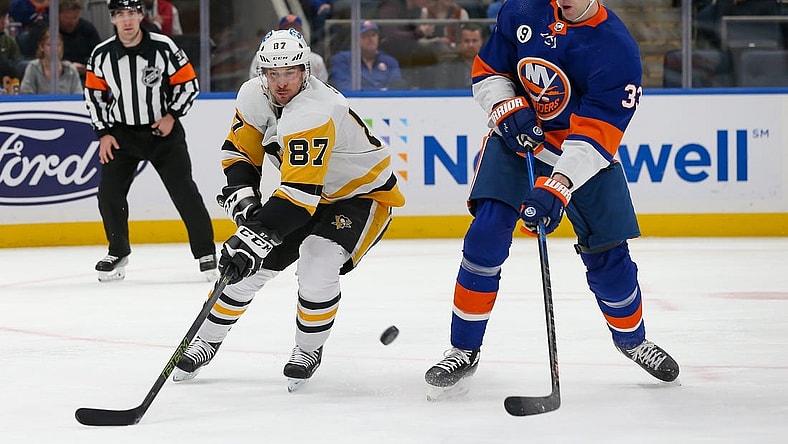 Apr 12, 2022; Elmont, New York, USA; Pittsburgh Penguins center Sidney Crosby (87) and New York Islanders defenseman Zdeno Chara (33) battle for the puck during the first period at UBS Arena. Mandatory Credit: Tom Horak-USA TODAY Sports