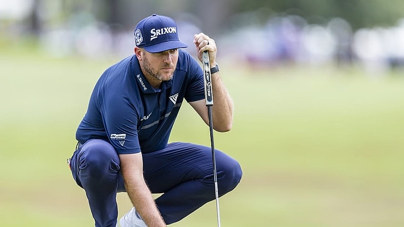 Jul 31, 2022; Detroit, Michigan, USA; Taylor Pendrith places his ball on the green on the par 4 first hole during the final round of the Rocket Mortgage Classic golf tournament. Mandatory Credit: Raj Mehta-USA TODAY Sports