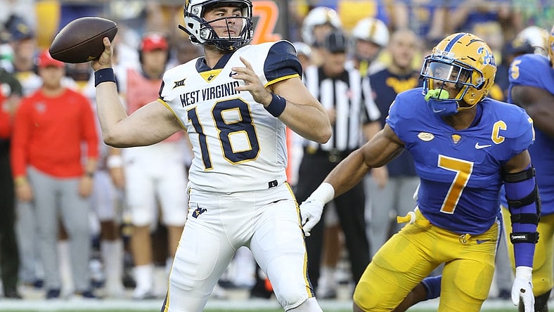 Sep 1, 2022; Pittsburgh, Pennsylvania, USA; West Virginia Mountaineers quarterback JT Daniels (18) passes against pressure from Pittsburgh Panthers linebacker SirVocea Dennis (7) during the first quarter at Acrisure Stadium. Mandatory Credit: Charles LeClaire-USA TODAY Sports