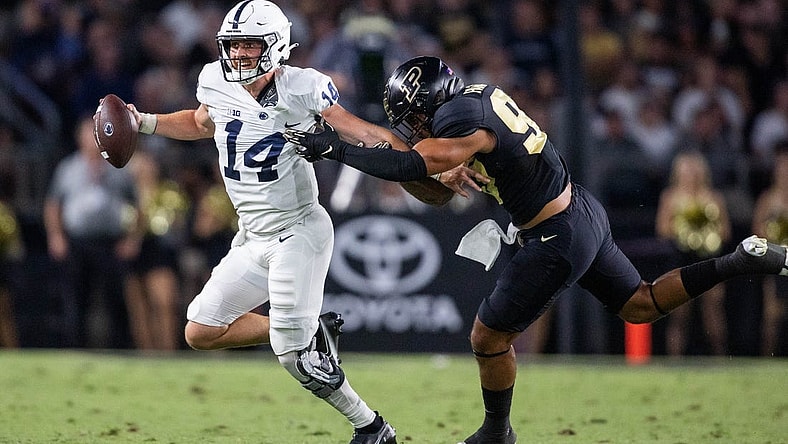 Sep 1, 2022; West Lafayette, Indiana, USA; Penn State Nittany Lions quarterback Sean Clifford (14) runs to pass the ball while Purdue Boilermakers defensive tackle Lawrence Johnson (90) defends  in the second quarter at Ross-Ade Stadium. Mandatory Credit: Trevor Ruszkowski-USA TODAY Sports