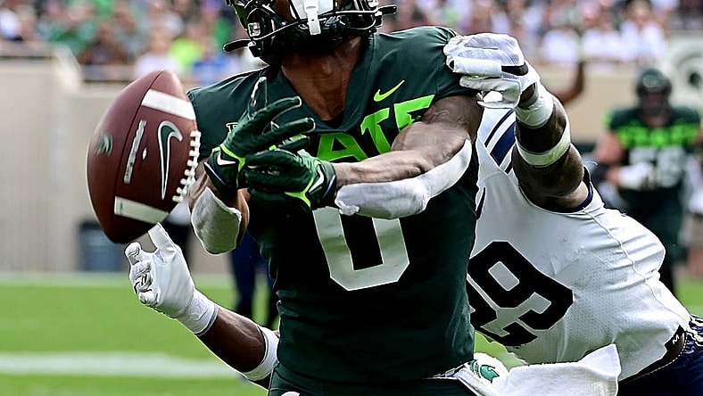 Sep 10, 2022; East Lansing, Michigan, USA;   Michigan State Spartans wide receiver Keon Coleman (0) can not hold onto the ball after being hit by Akron Zips cornerback Jalen Hooks (29). Mandatory Credit: Dale Young-USA TODAY Sports