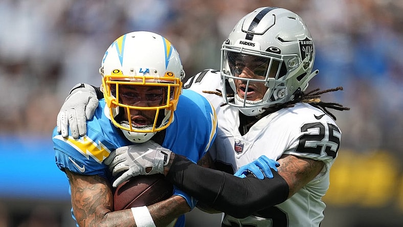 Sep 11, 2022; Inglewood, California, USA; Los Angeles Chargers wide receiver Keenan Allen (13) tries to break free from the grasp of Las Vegas Raiders safety Tre'von Moehrig (25) in the first half at SoFi Stadium. Mandatory Credit: Kirby Lee-USA TODAY Sports