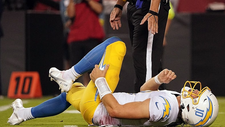 Sep 15, 2022; Kansas City, Missouri, USA; Los Angeles Chargers quarterback Justin Herbert (10) reacts after being hit by Kansas City Chiefs defensive end Mike Danna (51) during the second half at GEHA Field at Arrowhead Stadium. Mandatory Credit: Denny Medley-USA TODAY Sports